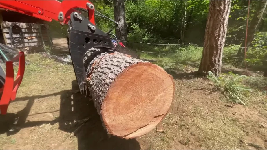Grapple loader moving a large tree log during lot clearing in Craighead County Arkansas